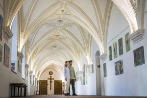 ein Paar betrachtet ein Bild im Kreuzgang des Klosters