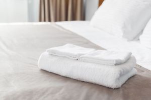 Hotelbett mit Kissen und Handtüchern