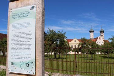 Stele 8 des Benediktusweges mit Basilika im Hintergrund