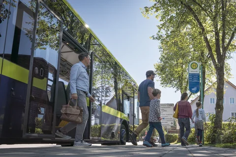 mehrere Fahrgäste steigen aus einem MVV-Bus aus