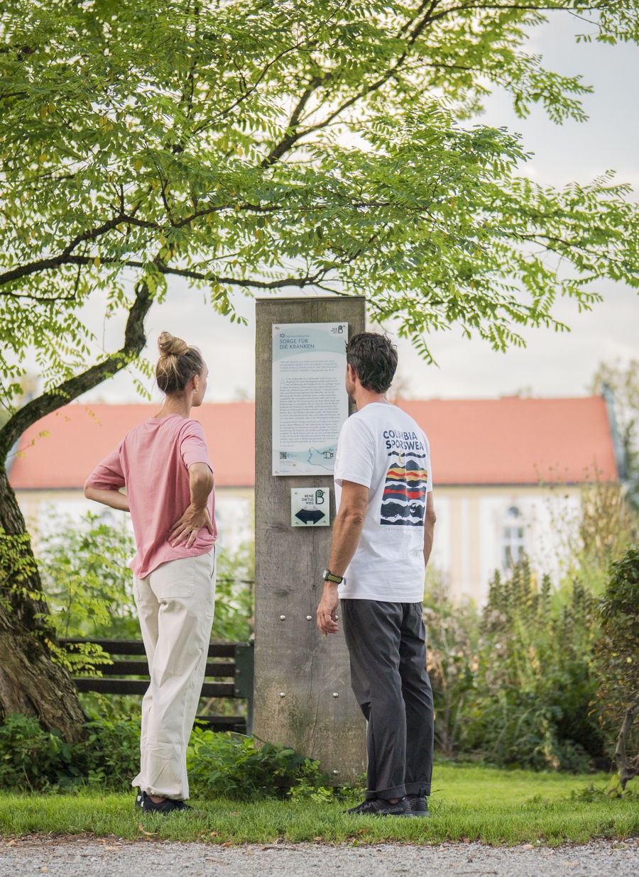 Paar liest den Text der Stele 10 am Benediktusweg